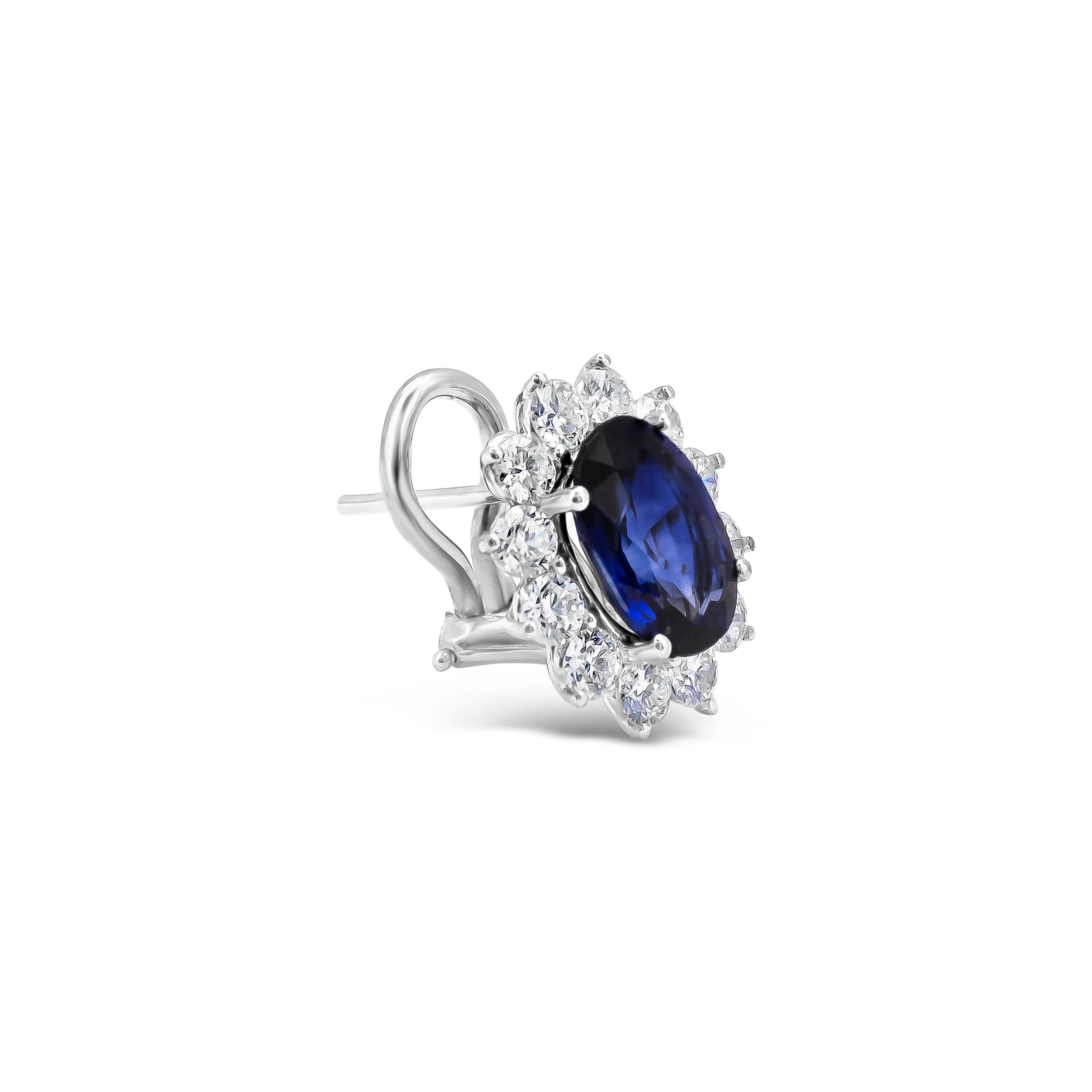 Elegant and classic clip earrings showcasing beautiful oval cut blue sapphires weighing 3.96 carats total. Each sapphire securely sit in a dazzling diamond surround weighing 1.75 carats total. Omega Clip in 18k white gold.

Style available in