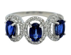 Oval Cut Blue Sapphire and Diamond Halo Three Stone Ring in 18 Karat White Gold