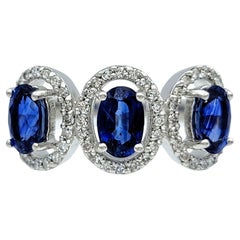 Oval Cut Blue Sapphire and Diamond Halo Three Stone Ring in 18 Karat White Gold