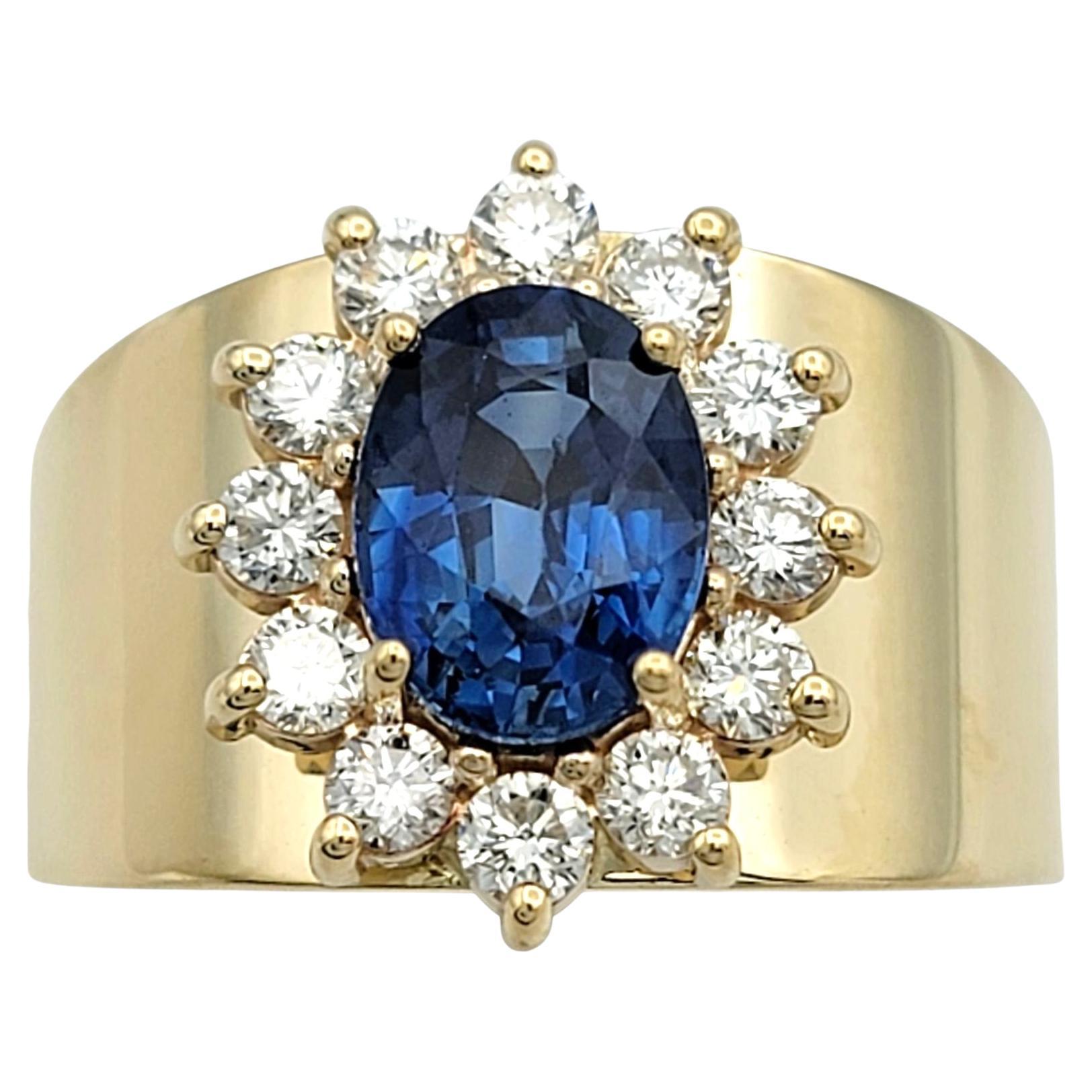 Anillo ancho con halo de diamantes y zafiro azul talla oval en oro amarillo de 14 quilates