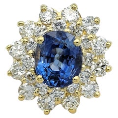 Anello con zaffiro blu taglio ovale e doppio diamante a raggiera in oro giallo 18 carati