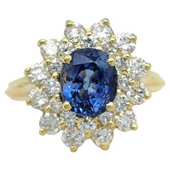 Anello con zaffiro blu taglio ovale e doppio diamante a raggiera in oro giallo 18 carati