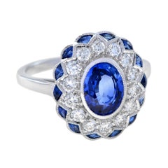 Anello con zaffiro blu taglio ovale e diamante in stile Art Deco con incastonatura a raggiera in oro bianco 18 carati