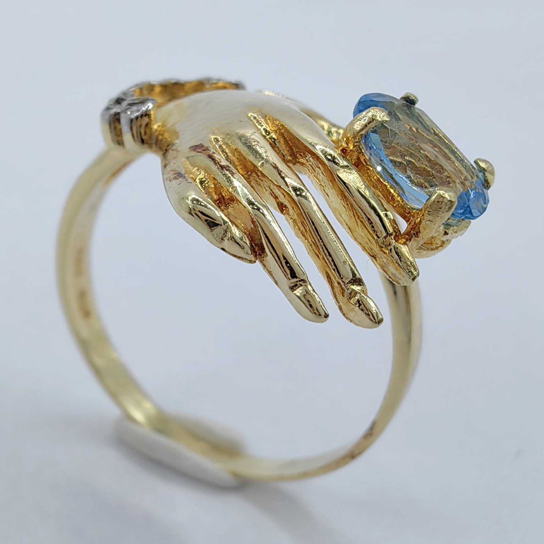 Contemporary Oval-cut Blue Topaz in a Hand Diamond Ring in 14K Yellow Gold For Sale