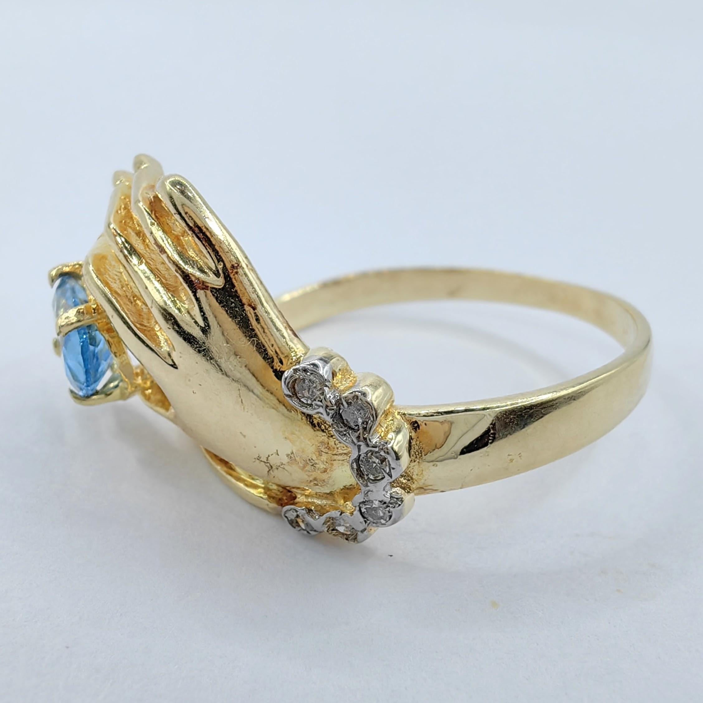 Oval Cut Oval-cut Blue Topaz in a Hand Diamond Ring in 14K Yellow Gold For Sale