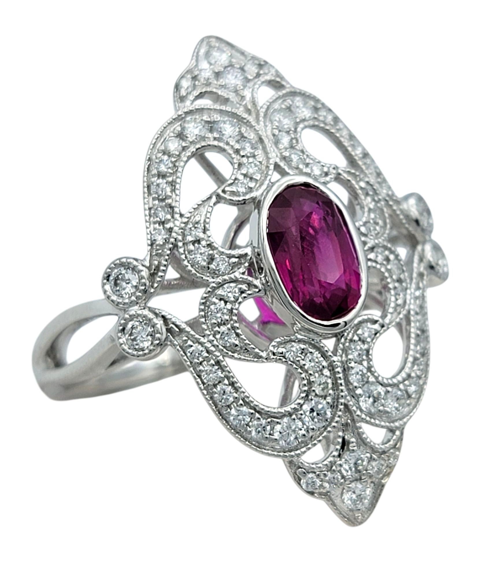 Ring Size: 7

This elegant ring showcases an oval-cut Burmese ruby at its center, framed by a delicate lattice pattern set with round brilliant-cut pavé diamonds. The open filigree design creates a sense of airiness and vintage charm, while the