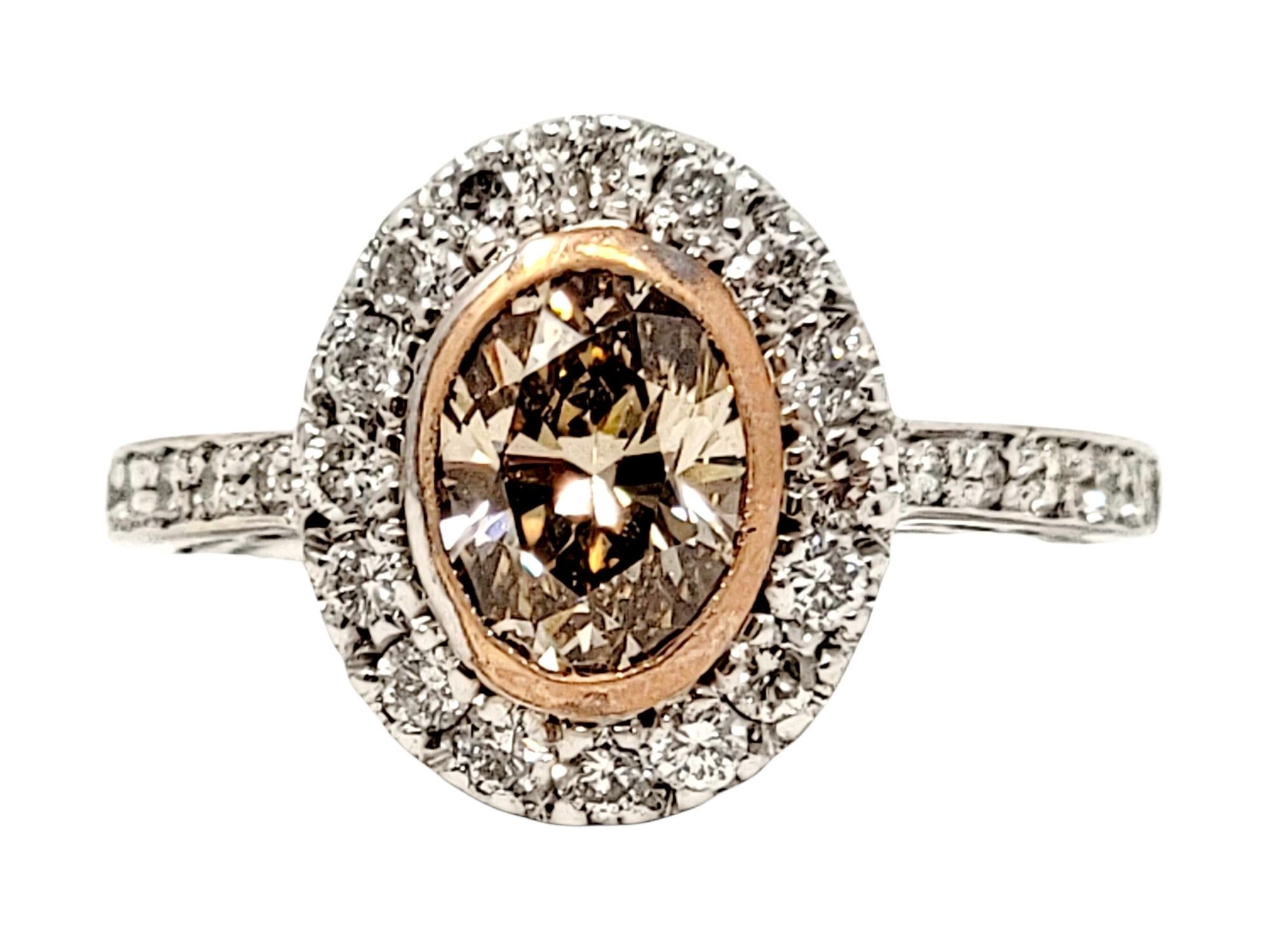 Ring size: 3.75

This absolutely gorgeous champagne diamond halo ring will light up your finger! It features a sparkling 1.00 carat Fancy Light Brown oval brilliant cut natural diamond bezel set in yellow gold at the center of the piece. Surrounding