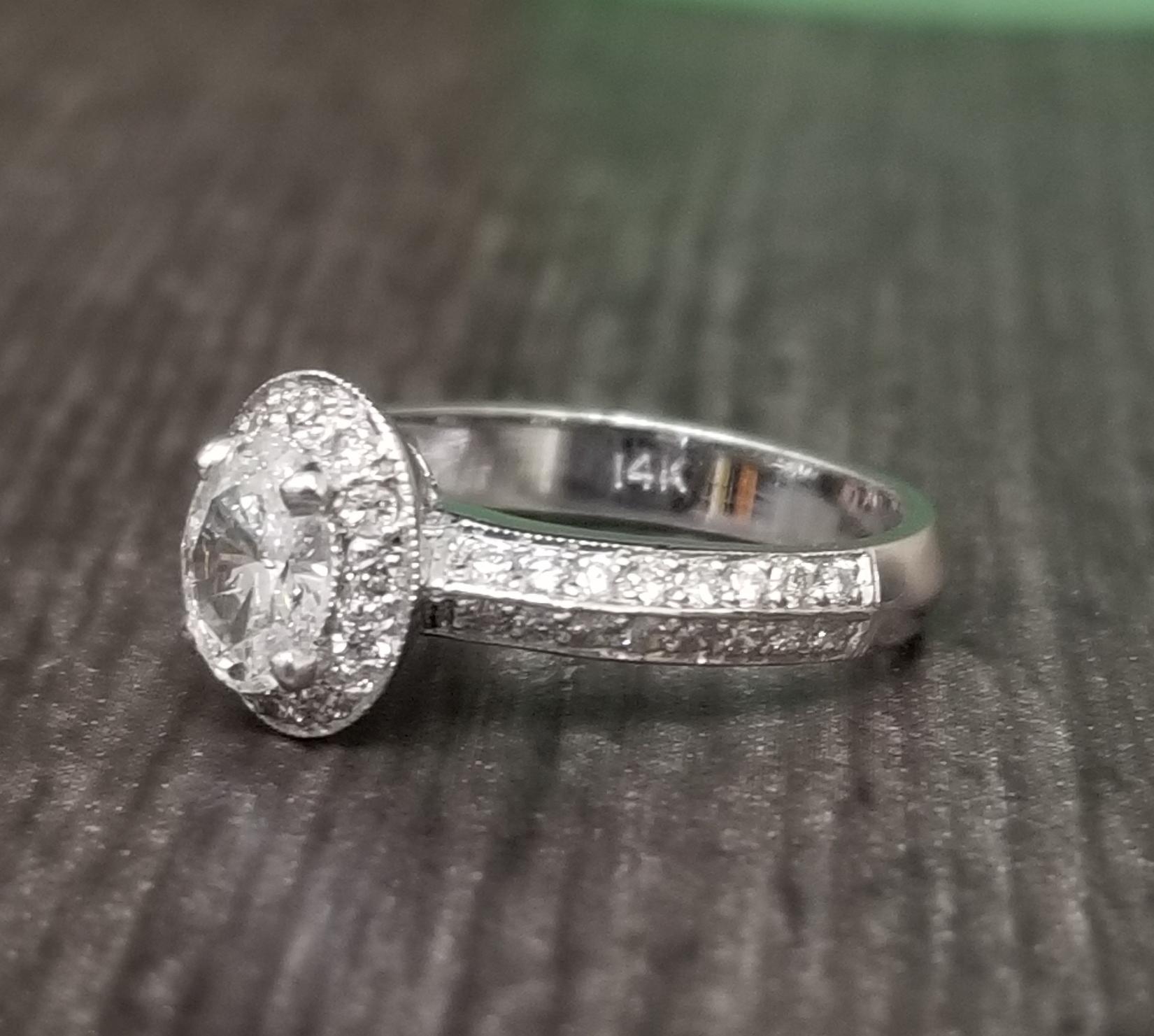 14k white gold ladies diamond ring containing 1 oval cut diamond weighing .60pts and 44 round full cut diamonds of very fine quality weighing .50pts. on a 2 row beveled shank.
