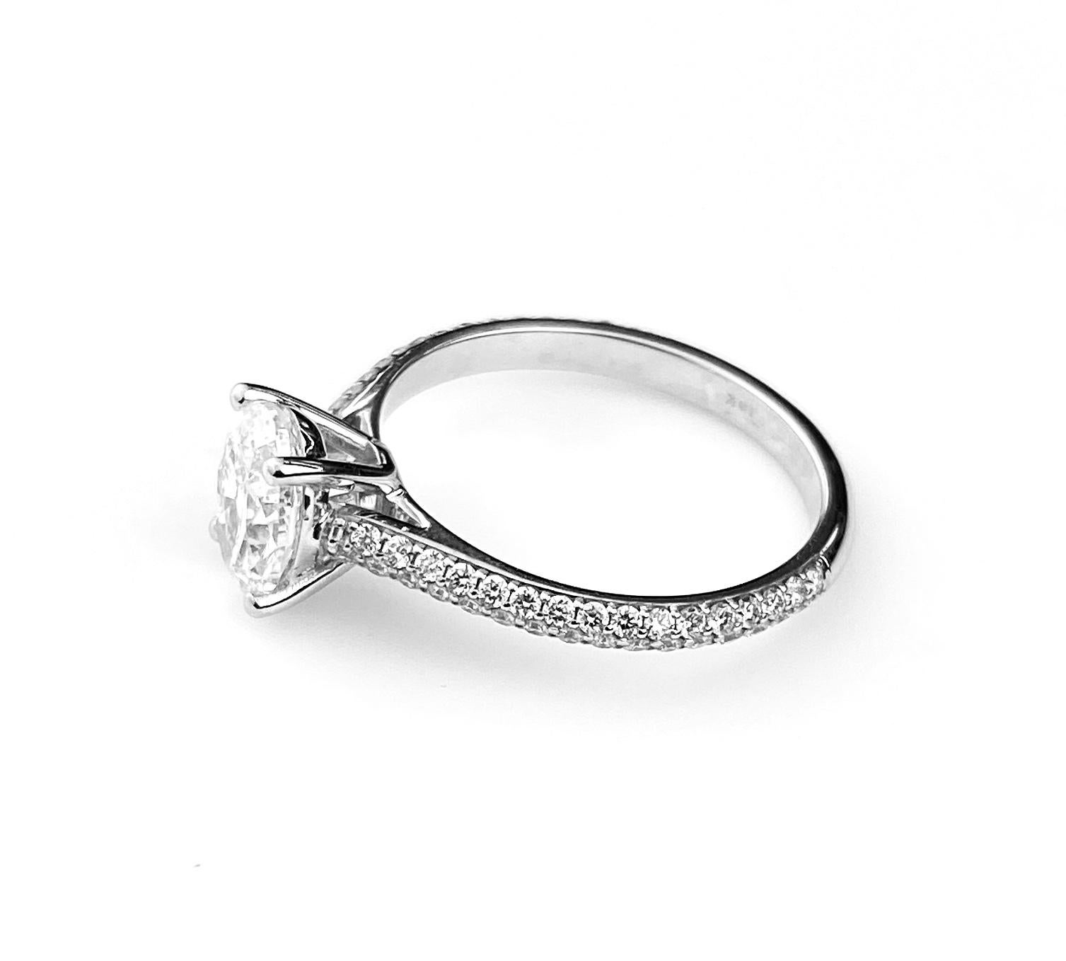 Oval cut diamond solitaire engagement ring with 1.01ct D SI1 center diamond GIA# 2127267236. Set in a 18kt white gold with two-row pave' band set 3/4 around the shank, with rising shoulders. Side diamonds equal 0.38ct total, and are F/G colour and