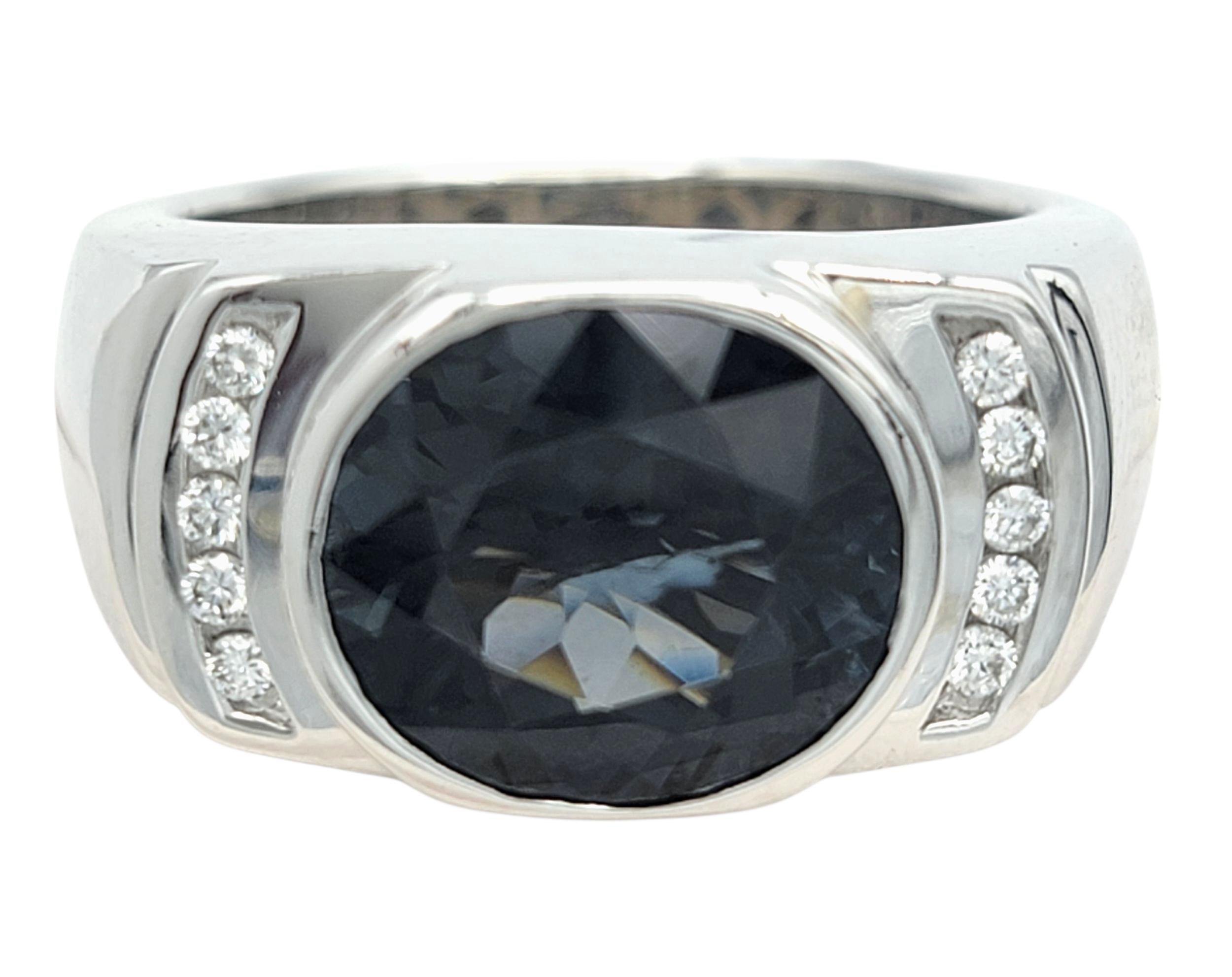 Taille de l'anneau : 9.75

Cette bague audacieuse et sophistiquée est centrée sur un spinelle de taille ovale bleu-gris foncé, offrant une brillance captivante et lunatique avec un éclat lisse et vitreux. Sa présence imposante est renforcée par son 