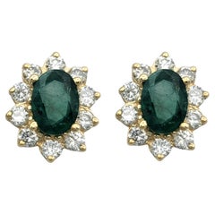 Oval Cut Emerald and Diamond Halo Stud Earrings in 14 Karat Yellow Gold