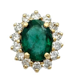 Oval Cut Emerald and Diamond Halo Stud Earrings in Polished 14 Karat Yellow Gold