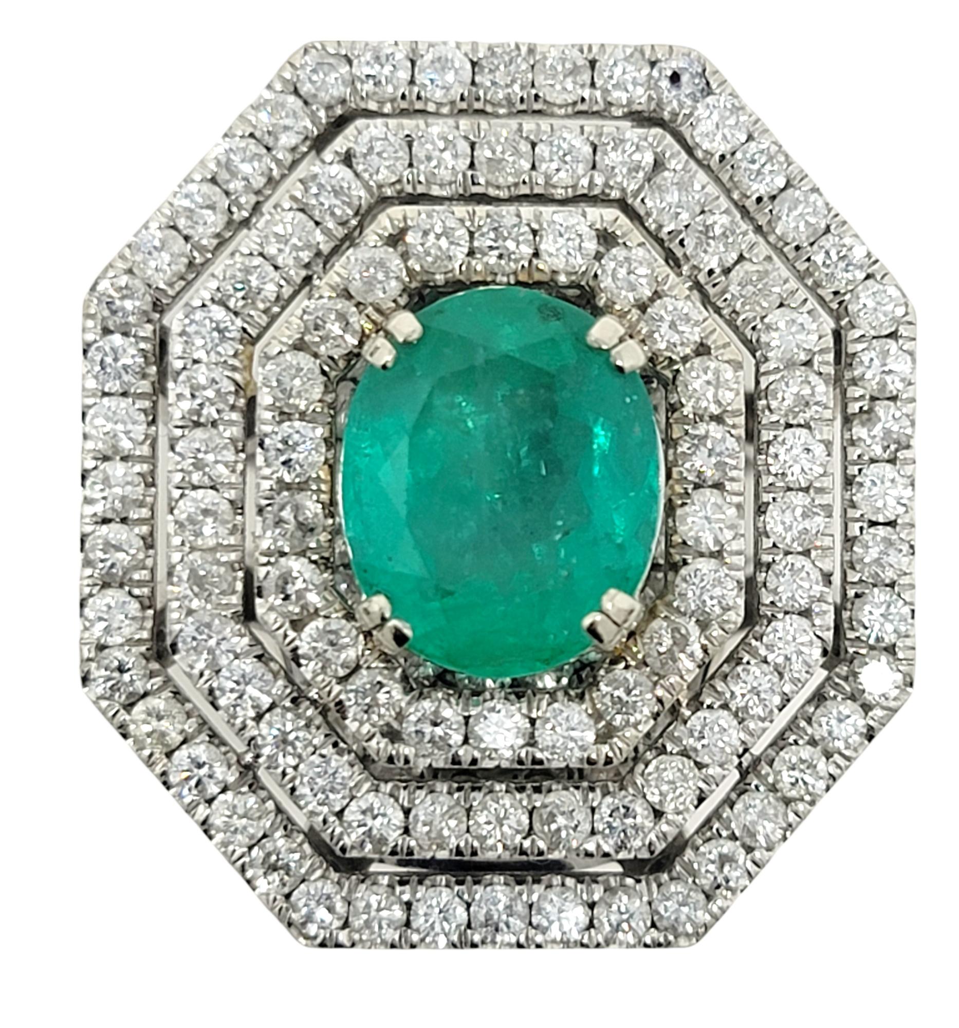 Ring size: 7

This incredible, jaw-dropping emerald and diamond cocktail ring is the absolute epitome of glamour. It features a single oval cut natural emerald in a stunning bluish-green color, double prong set at the center of the piece. A triple