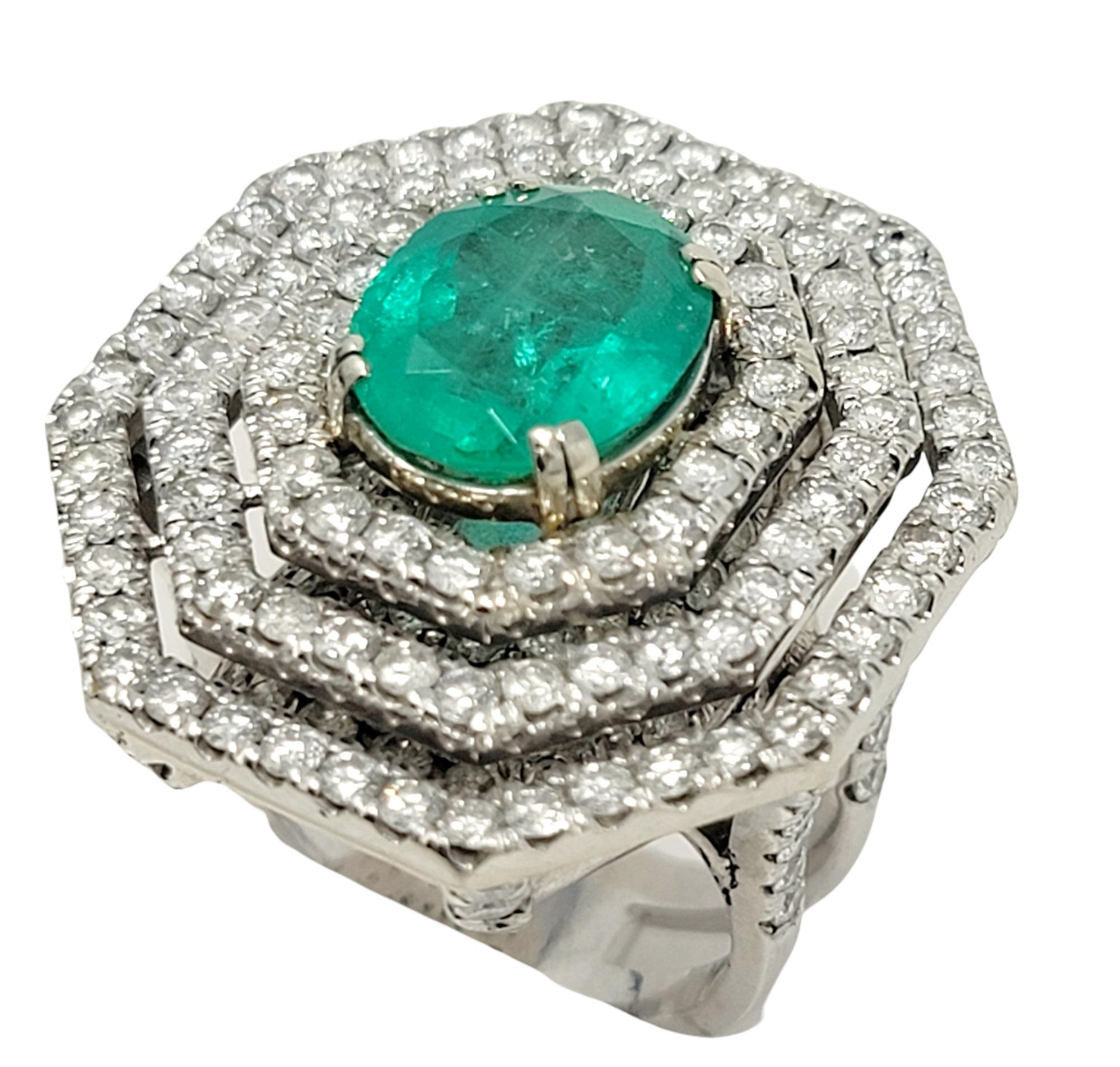 Contemporary Oval Cut Emerald and Diamond Triple Halo Split Shank Cocktail Ring 14 Karat Gold For Sale