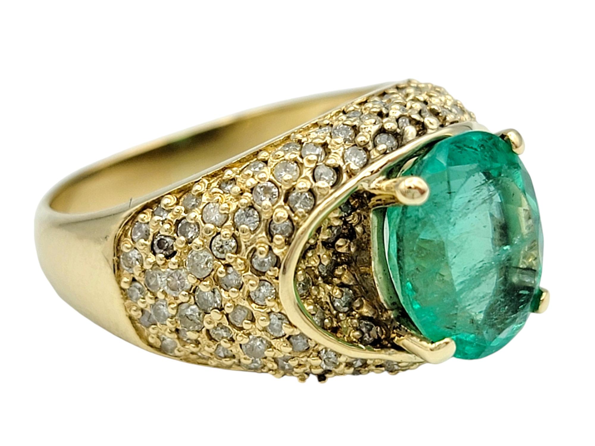 Contemporary Oval Cut Emerald and Pave Diamond Domed Band Ring in 14 Karat Yellow Gold For Sale