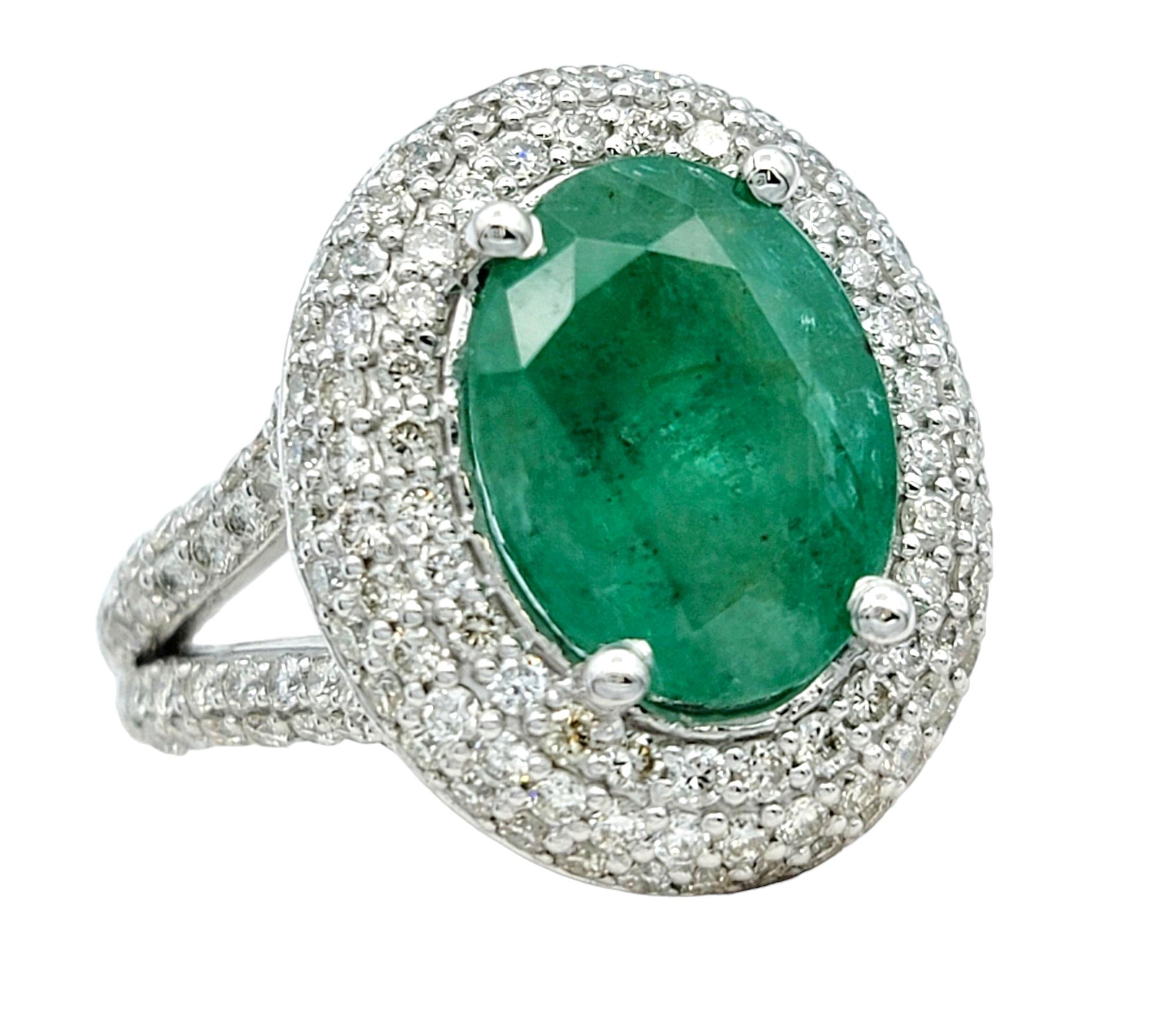 Contemporary Oval Cut Emerald and Pavé Diamond Double Halo Cocktail Ring 14 Karat White Gold For Sale