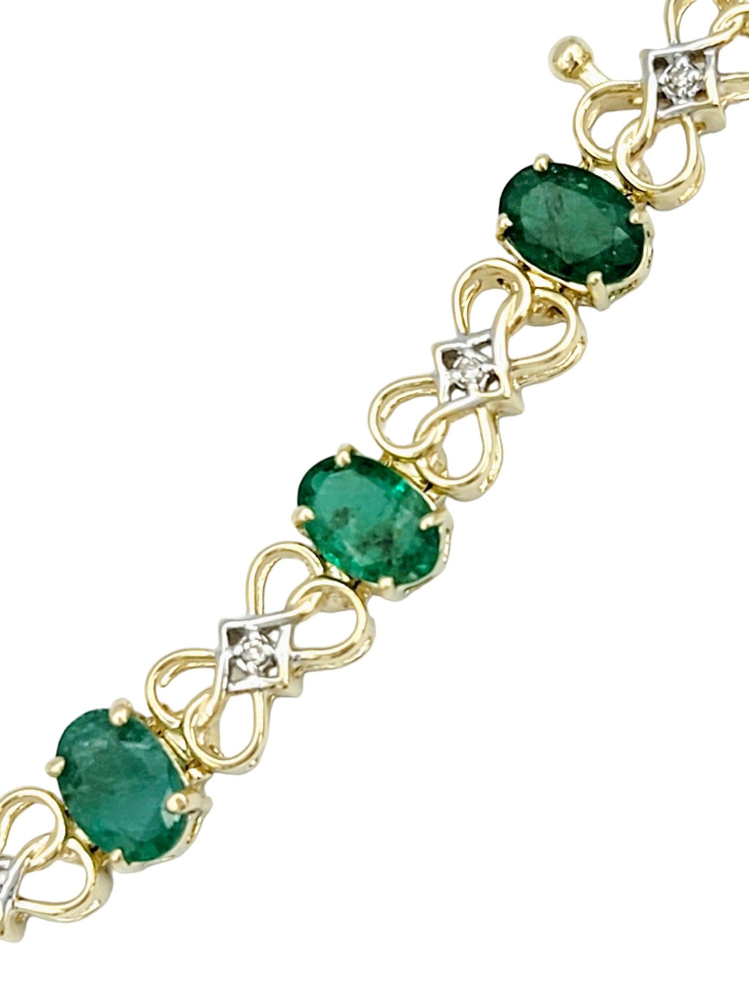 This elegant 14 karat gold tennis bracelet is a breathtaking testament to the timeless allure of emeralds and diamonds. The bracelet's design is a harmonious interplay of vibrant oval emeralds, each exuding a lush green hue, and infinity loop motifs