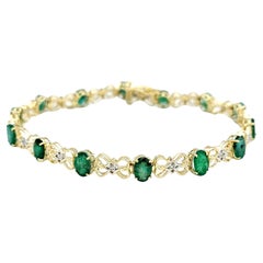 Bracelet tennis bicolore en or 14 carats serti d'émeraudes de taille ovale et de diamants ronds