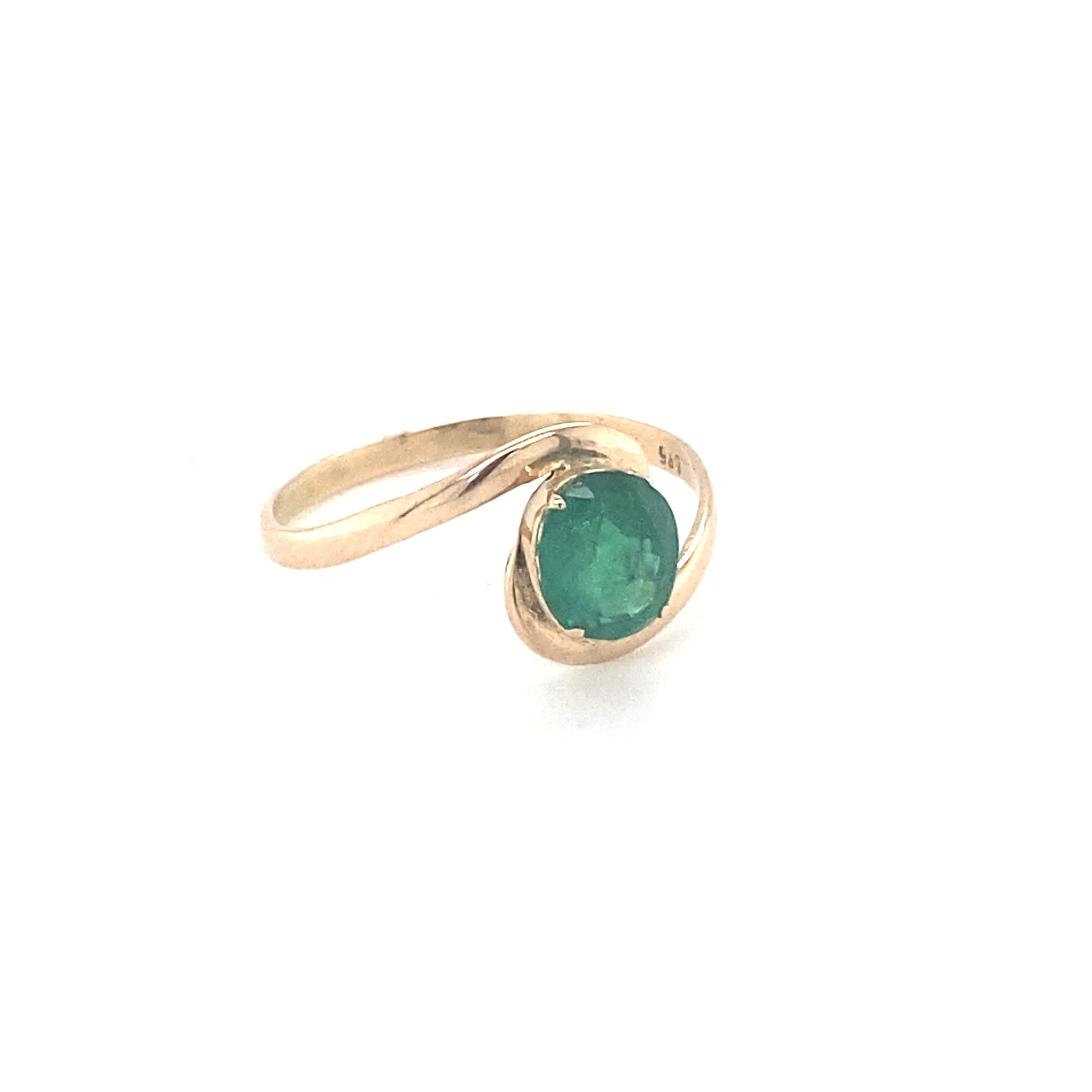 Oval cut emerald is mounted in 14K yellow gold. Beautifully hand crafted ring in double twisted design is suitable for your everyday companion. Carefully chosen gem stone is hand cut and polished. One of a kind ring to suit your style. Its sleek and