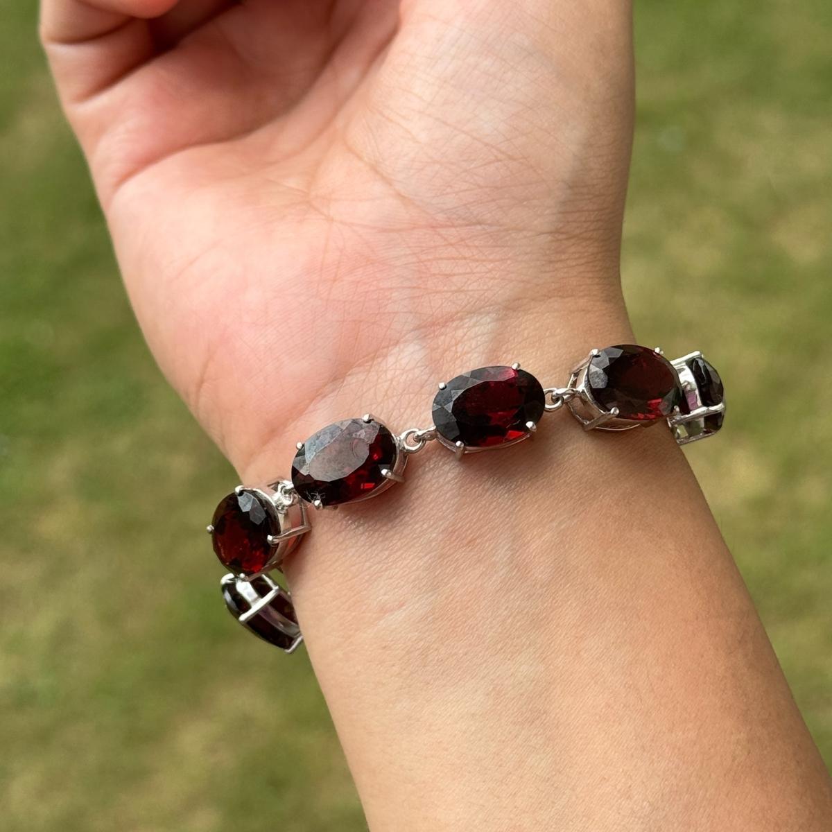 Questo splendido braccialetto regolabile Oval Cut Garnet Gemstones Line Bolo presenta una fila di gemme di granato di taglio ovale dalle tonalità intense, ognuna delle quali è sapientemente incastonata in un luccicante argento 925. Progettato con