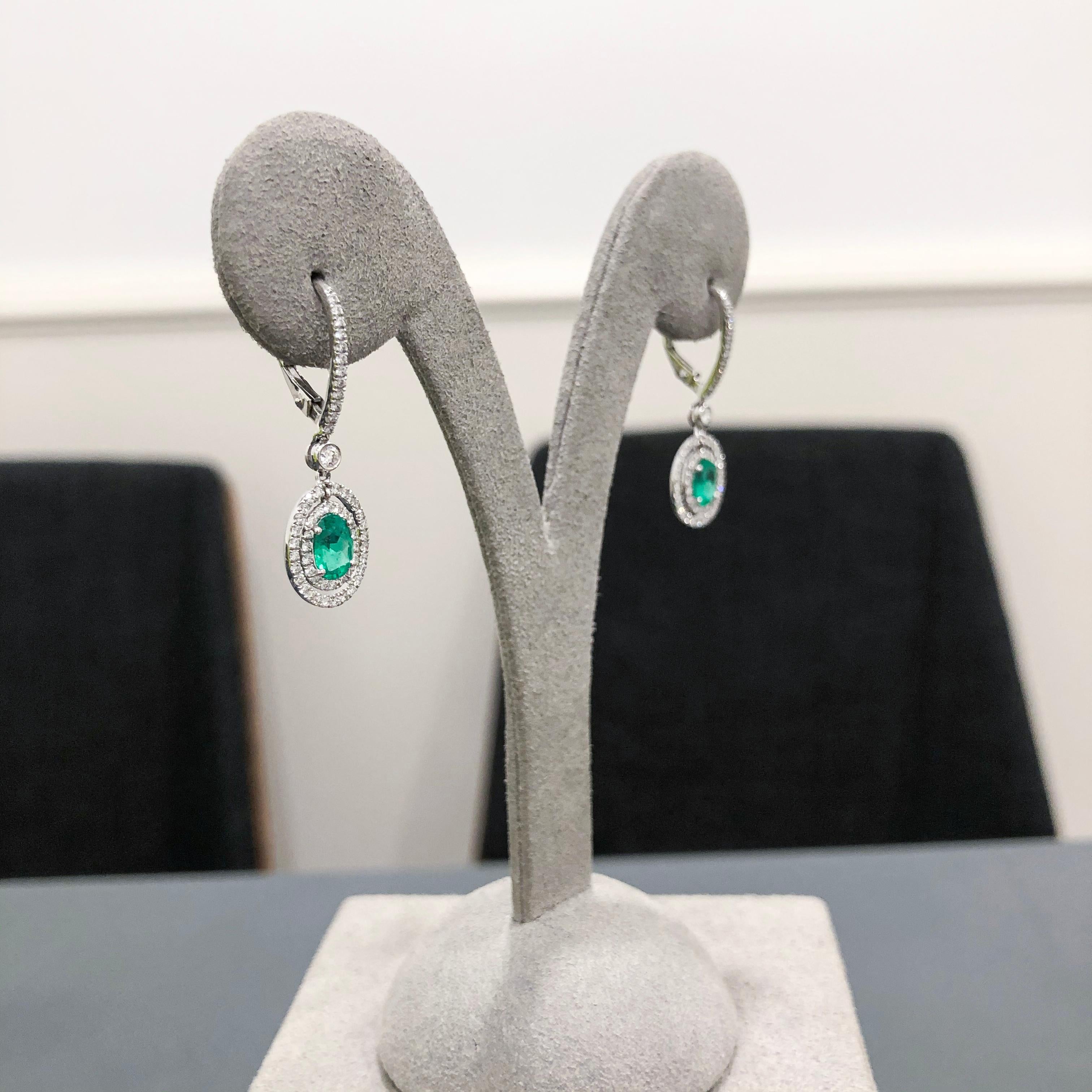 1.01 Carats Total Oval Cut Emerald and Diamond Halo Dangle Earrings In New Condition For Sale In New York, NY