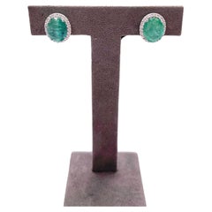 Boucles d
oreilles en or blanc 18K avec émeraude verte de taille ovale et halo de diamants