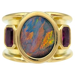 Breiter Ring mit Opal im Ovalschliff und Rubin im Strahlenschliff aus 18 Karat Gelbgold