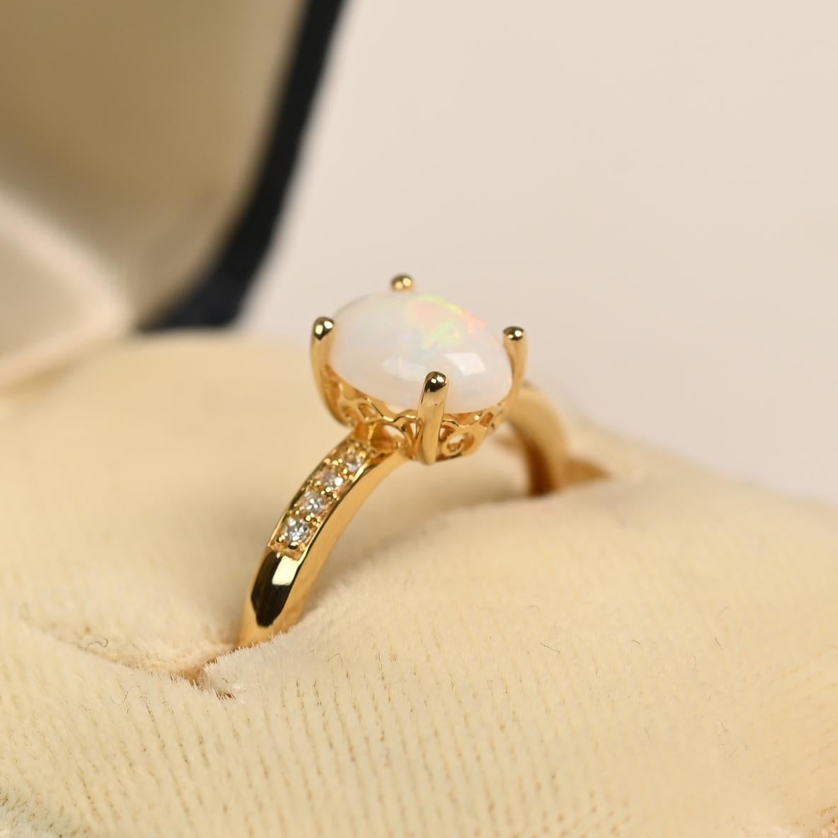 Cette magnifique bague est ornée d'une opale de taille ovale pesant environ 0,70 carats, solidement sertie dans une monture classique à griffes. L'opale présente un jeu de couleurs douces et fascinantes, créant un point focal captivant.

Les épaules