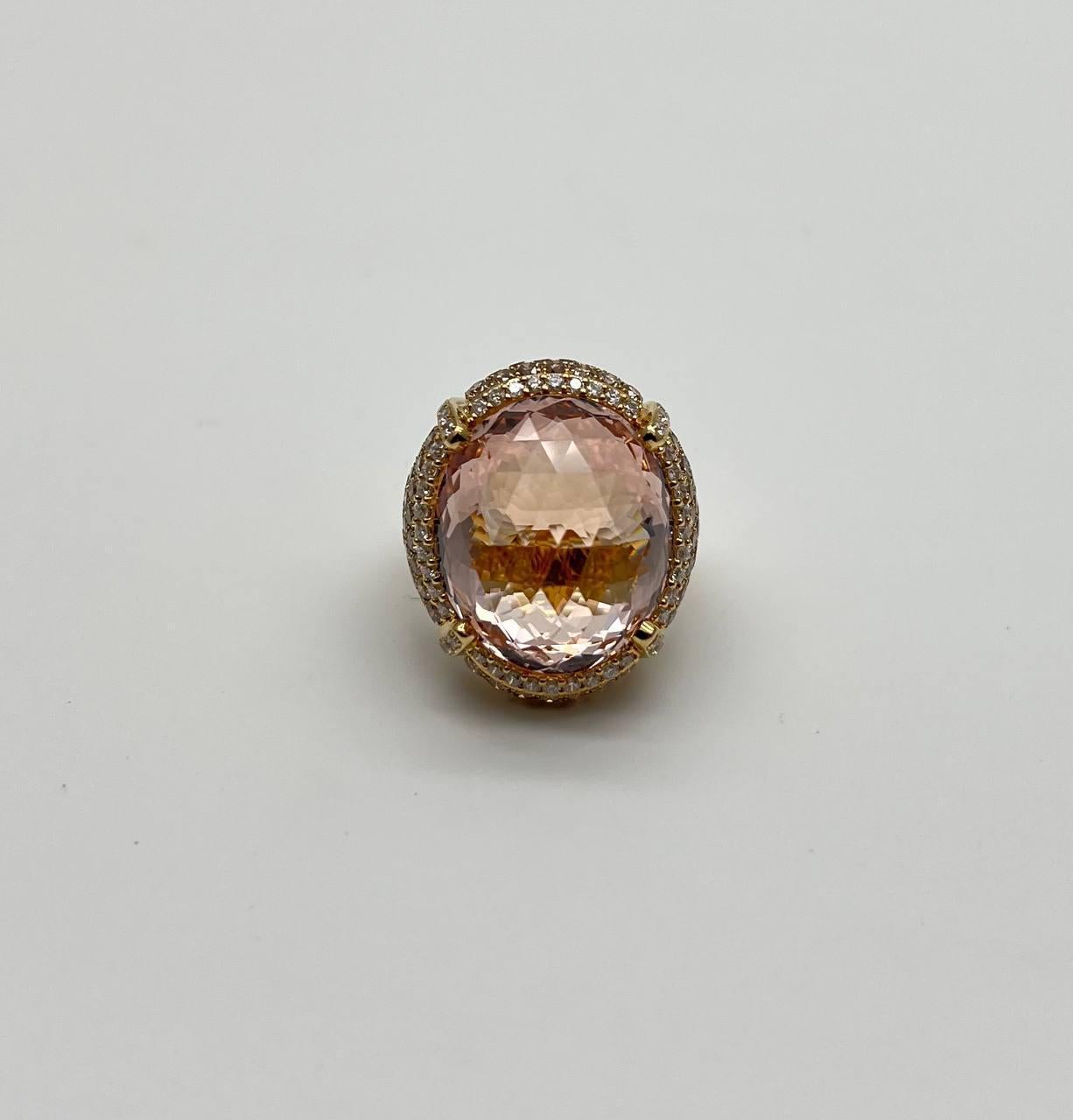 Cette pièce exquise présente une grande morganite orange pêche de taille ovale, d'une teinte pêche captivante. La pierre est sertie dans un luxueux anneau d'or, entouré d'un halo de diamants de couleur fantaisie pavés plus petits et étincelants qui