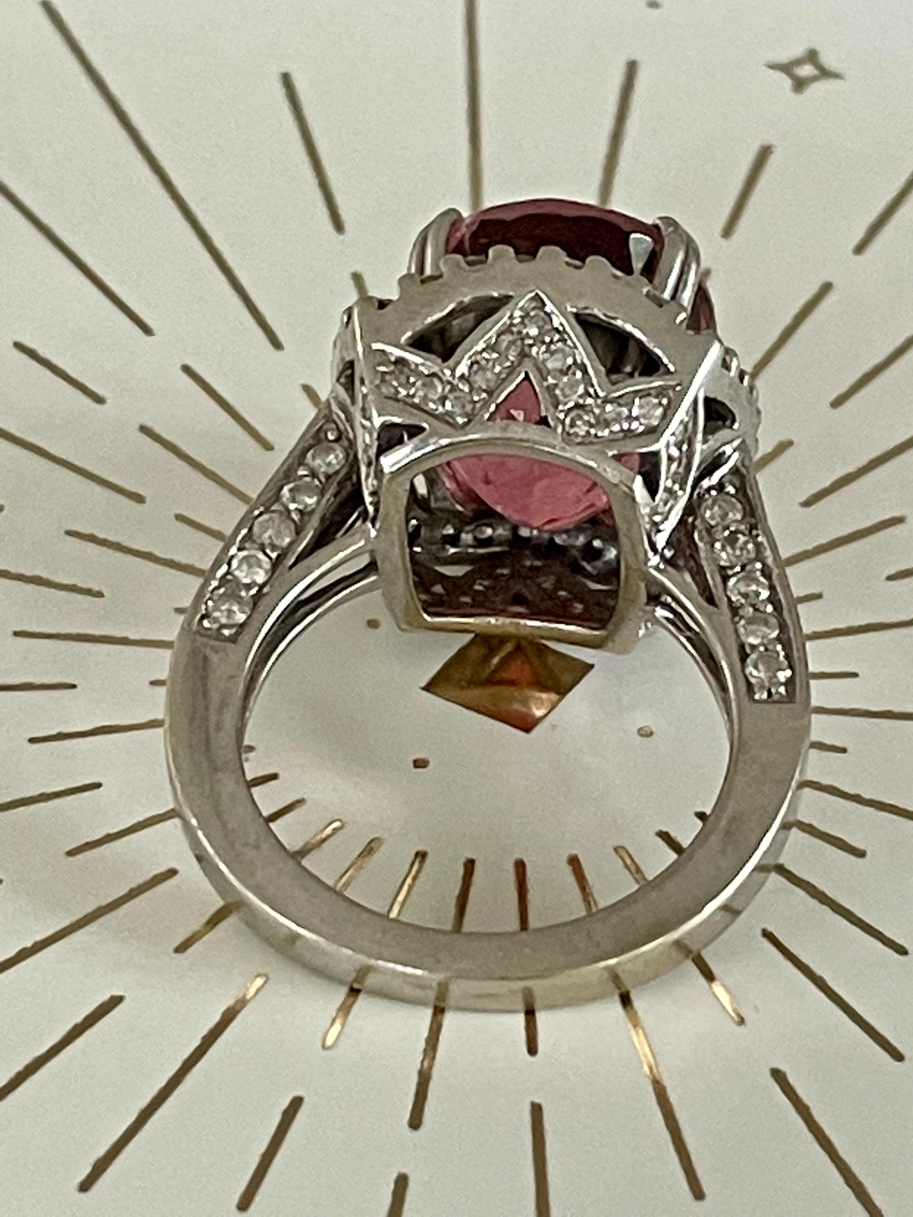 This ring is absolutely breath-taking.  It features an oval cut pink Tourmaline which measures 15 x 12mm.  The stone is approximately 8.5ct.  There are brilliant cut side Diamonds too numerous to count which adorn every side and angle of the
