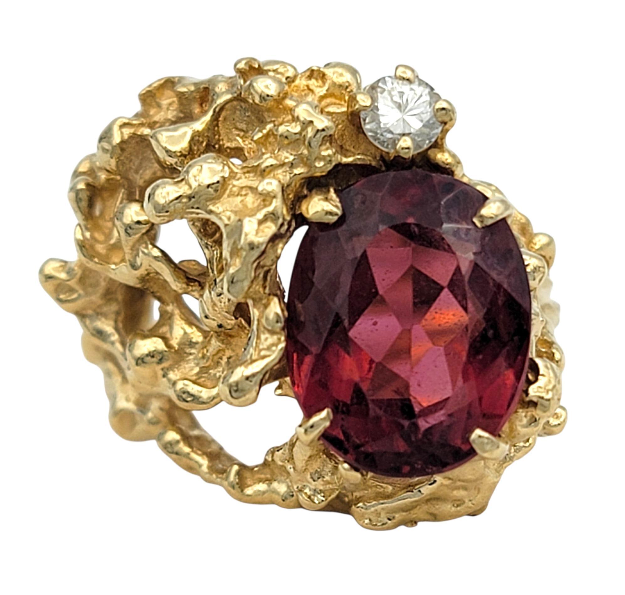 Dieser Ring zeigt einen auffälligen tiefrosa Mittelstein, der mit seiner kräftigen, leuchtenden Farbe sofort ins Auge fällt. Der ovale Edelstein sitzt in einer verschnörkelten Fassung aus Gelbgold, die voller Textur und Bewegung ist und dem