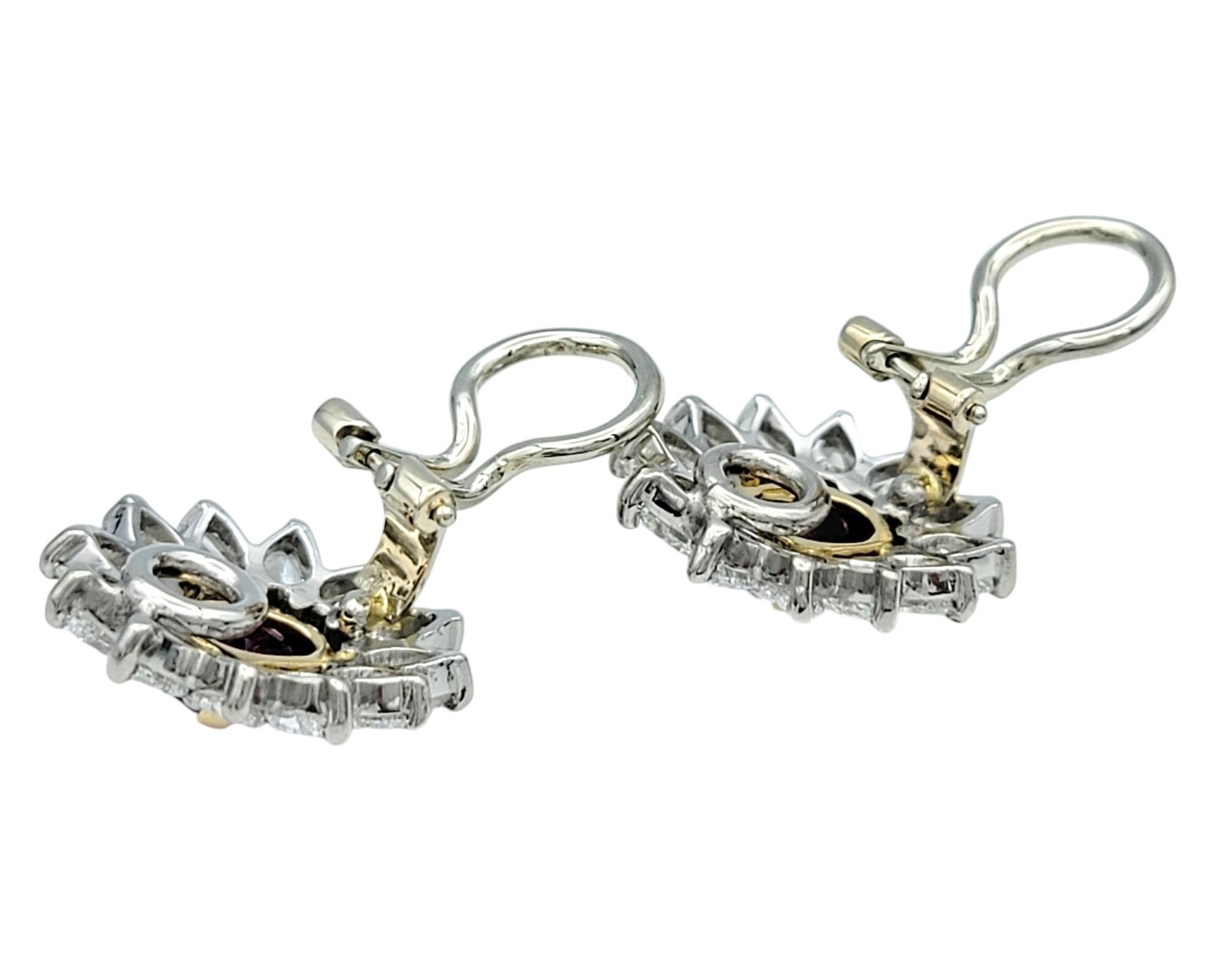 Indulge in the timeless beauty of these stunning earrings that perfectly blend opulence and craftsmanship. At their heart lies a vivid oval-cut ruby, radiating rich, fiery hues, cradled in elegant 18 karat yellow gold prongs. The ruby’s bold allure