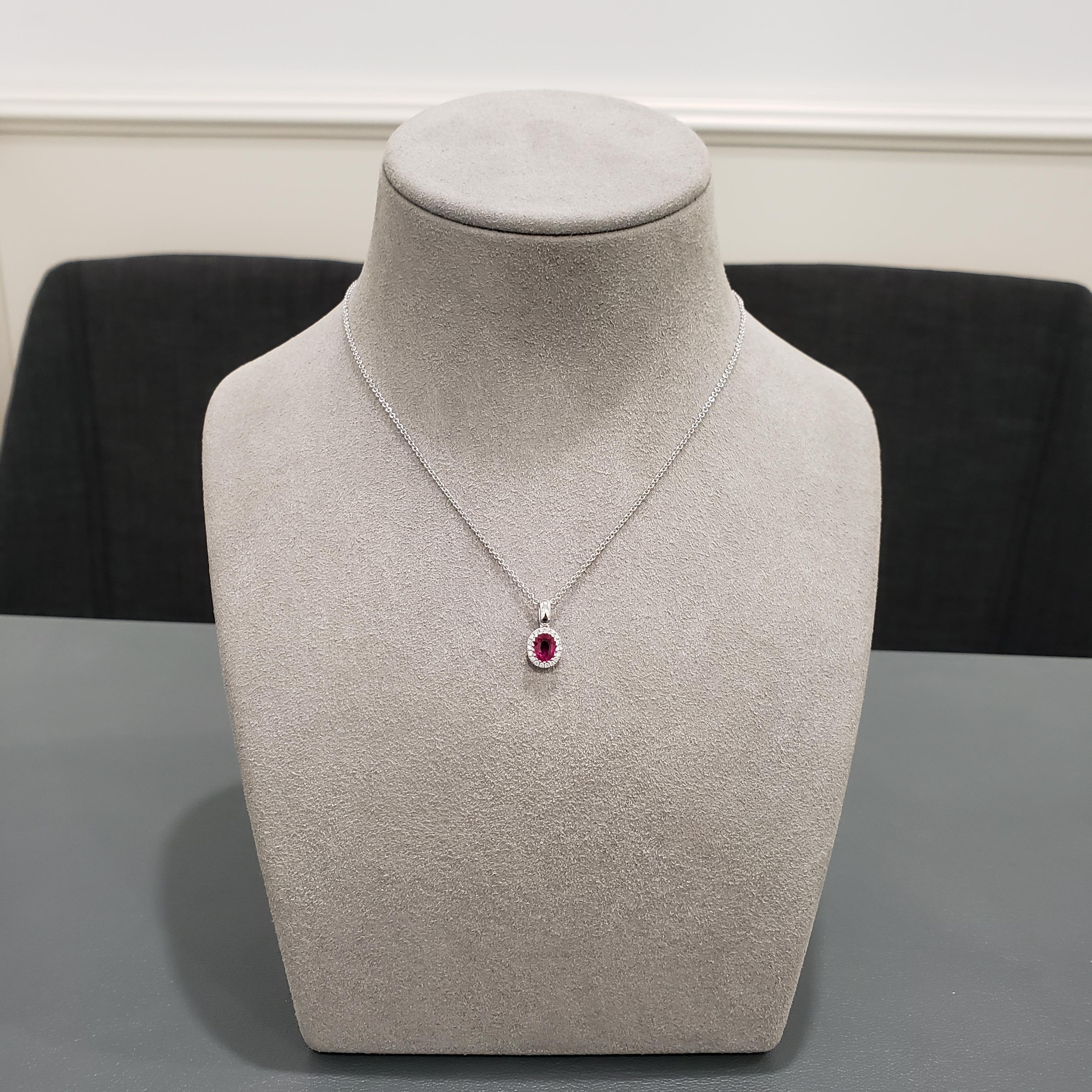 A floral motif pendant necklace showcasing a 0.70 carat oval ruby, surrounded by a single row of round brilliant diamonds. Made in 18K White Gold, Suspended on a 16 inch white gold chain. 

Style available in different price ranges. Prices are based