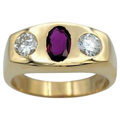 Anillo de tres piedras de oro amarillo de 14 quilates con rubí talla oval y diamante redondo