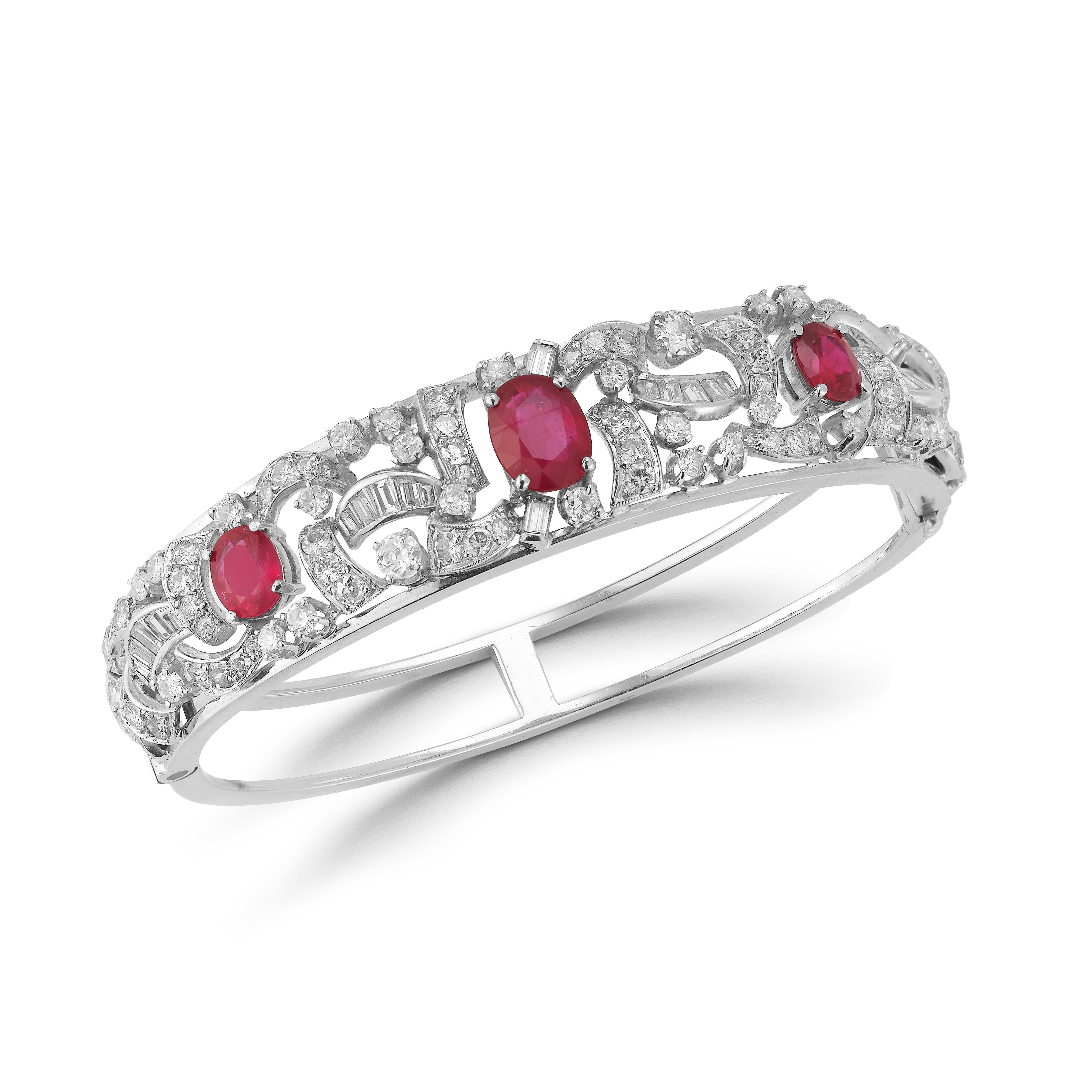 Oval Cut Ruby & Diamond Bangle Bracelet 3 oval cut rubies surrounded by round & baguette cut diamonds set in 14k white gold.

Ruby Weight: 5.26 cts 
Diamond Weight: 4.45 cts 

Measurements: 2.25