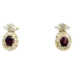 Oval Cut Ruby Earrings with Round Diamond Halos Set in 14 Karat Yellow Gold