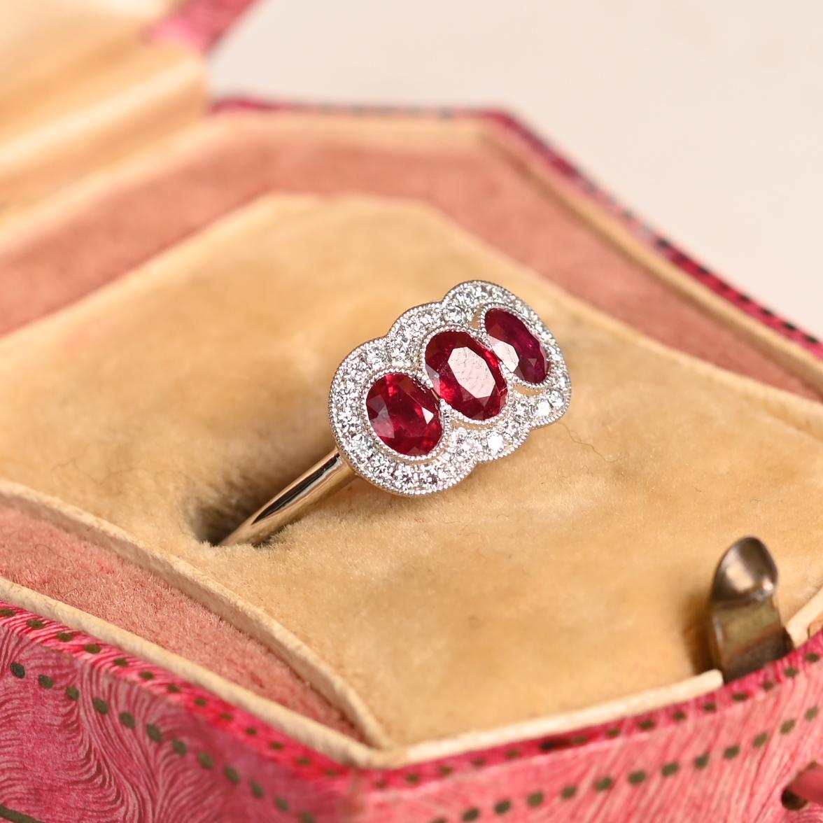 Cette exquise bague à trois pierres présente un trio de rubis ovales vibrants, élégamment sertis dans une orientation est-ouest à l'intérieur d'une monture en platine. Les rubis, d'une valeur totale d'environ 0,70 carat, sont sertis en biseau, ce