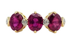 Oval Cut Ruby Three Stone Ring with Diamond Accents in 18 Karat Yellow Gold