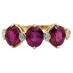 Bague à trois pierres en or jaune 18 carats avec rubis de taille ovale et accents de diamants