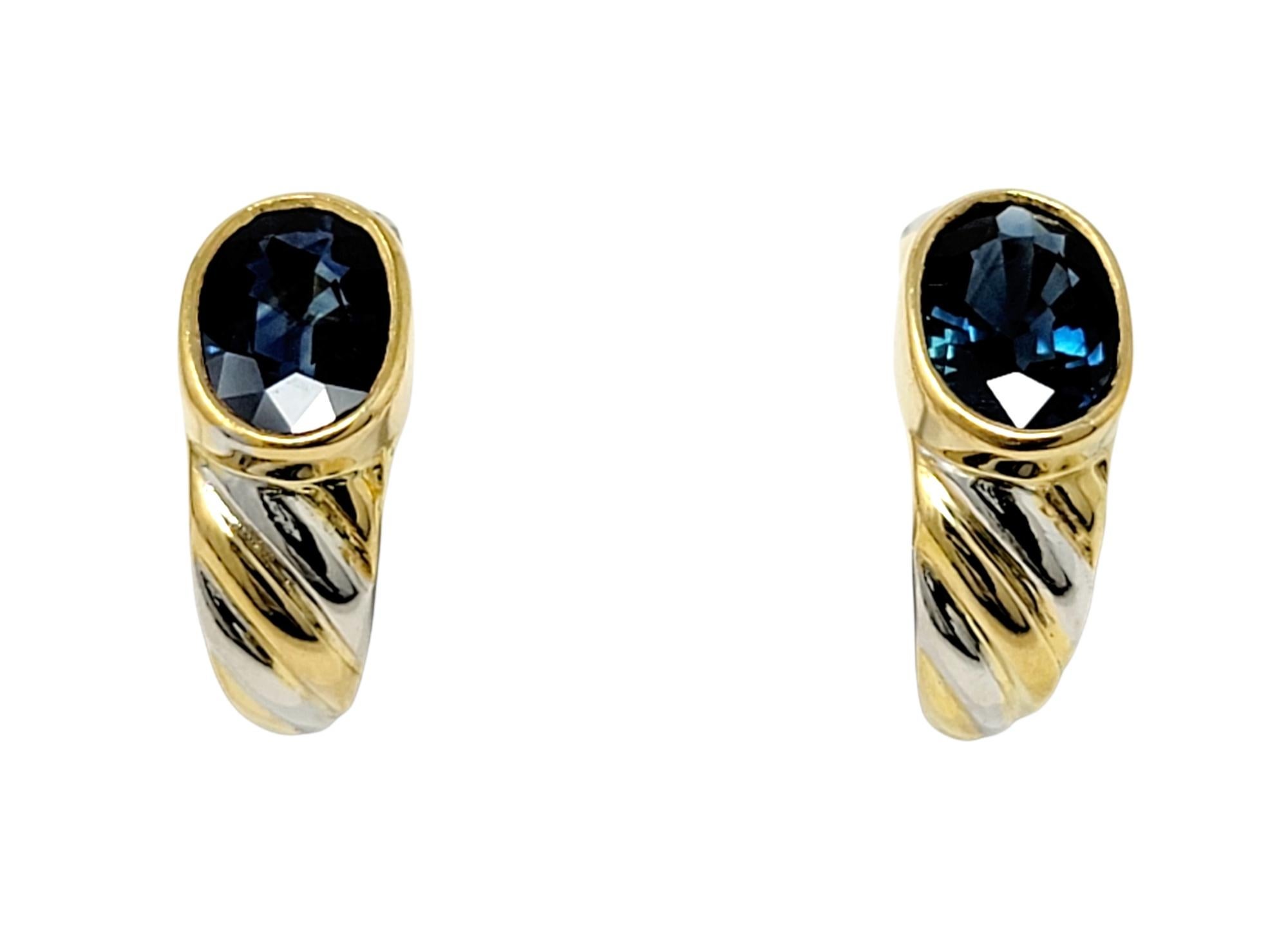 Luxurious two-tone gold twisted half hoop pierced earrings with stunning natural dark blue sapphire accents. 

Earring type: Half-Hoop
Metal: 18K Yellow & White Gold
Natural Sapphires: 2.86 carat total weight
Sapphire cut: Oval 
Weight: 6.3