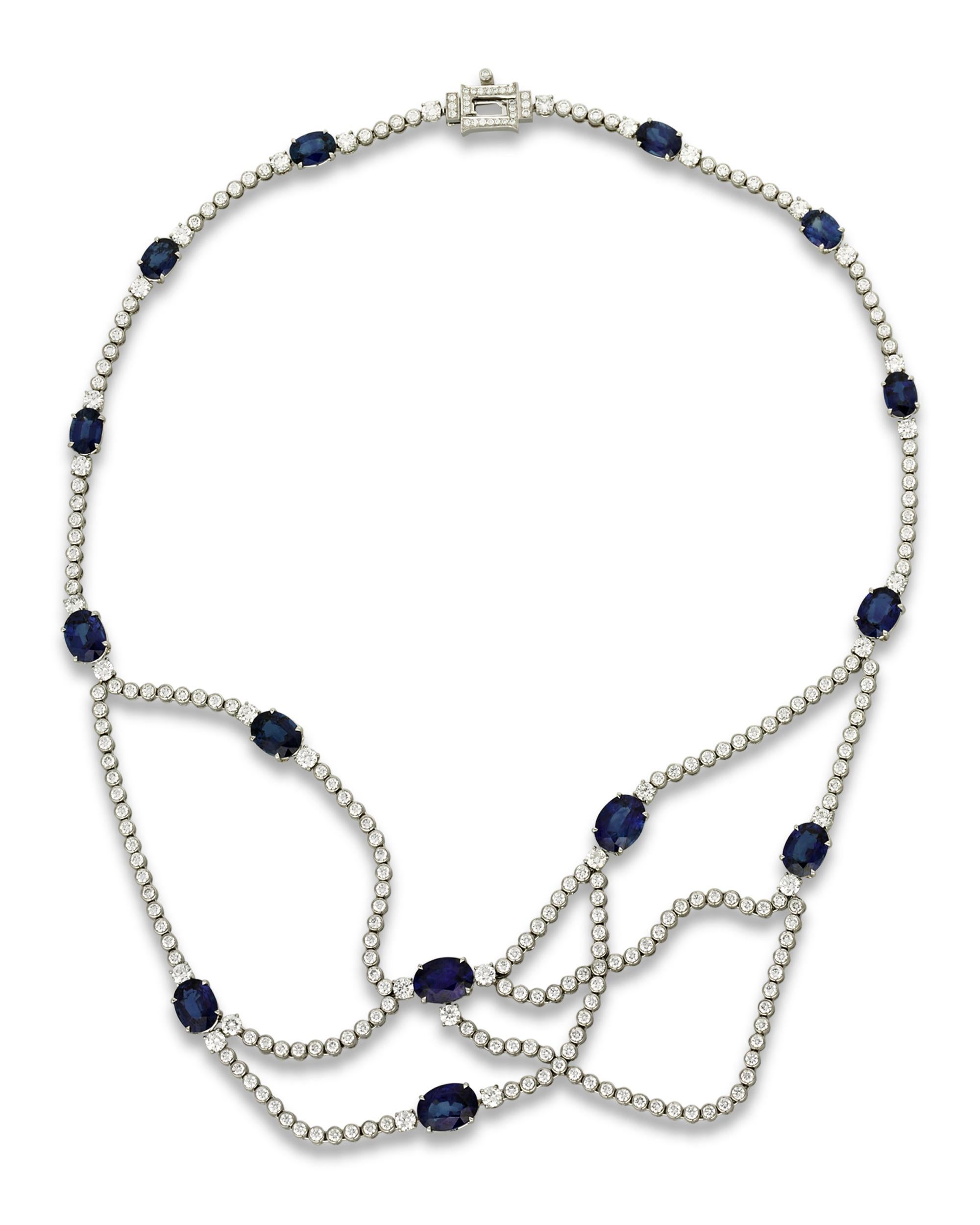 Fourteen perfectly matched oval-cut sapphires are set in this one-of-a-kind necklace. The gemstones total 20.13 carats and are joined by an astounding 260 brilliant white diamonds totaling 8.07 carats. The platinum setting drapes beautifully around