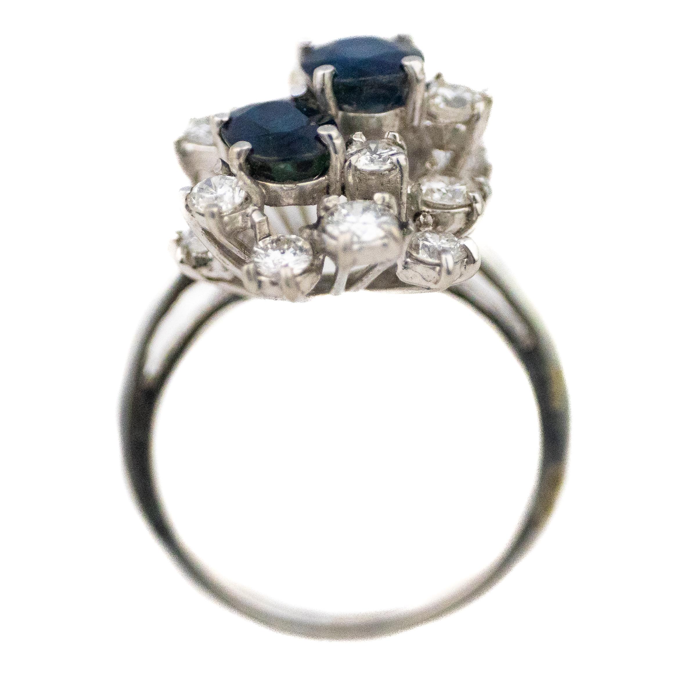 Cluster-Ring mit Saphiren im Ovalschliff und Diamanten im Brillantschliff

Beschreibung: Ein anmutiger Ring aus 18 Karat Weißgold mit zwei tiefblauen ovalen Saphiren, die von einem funkelnden Halo aus runden Diamanten im Brillantschliff umgeben
