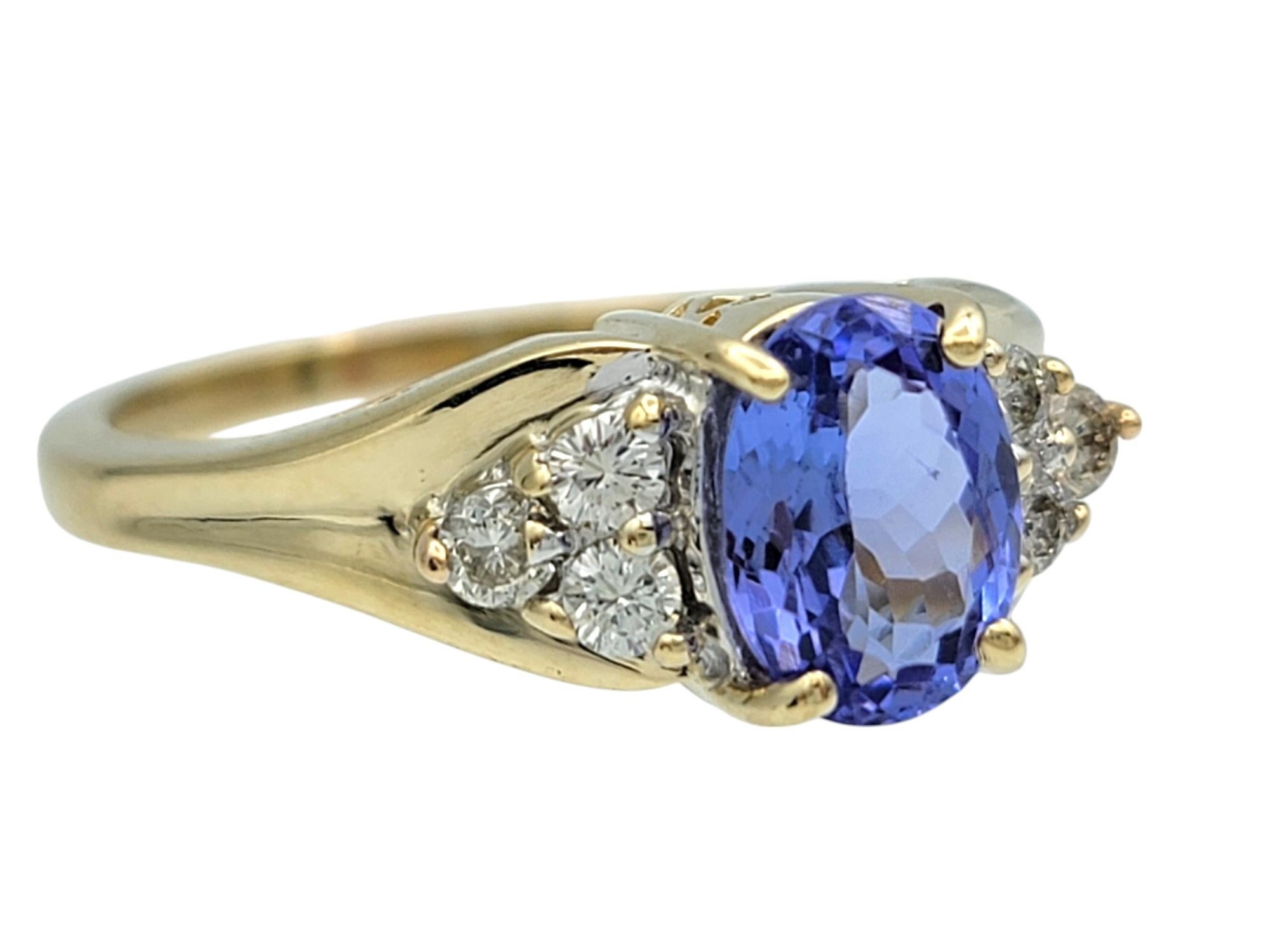 Ring Size: 8.5

This stunning tanzanite and diamond ring is a captivating statement of elegance and sophistication. At its center, an exquisite oval-cut tanzanite glows with a rich violet-blue hue, beautifully contrasted by the warm radiance of 14