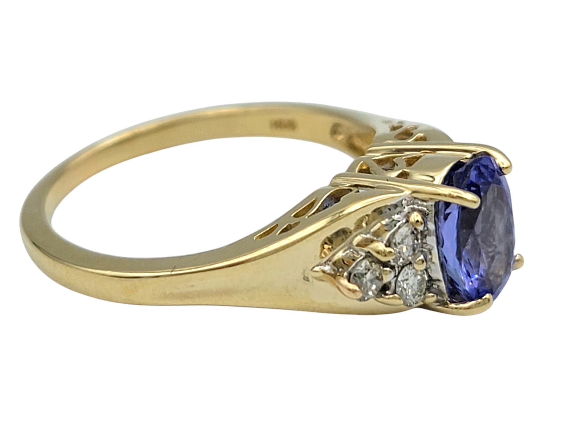 Contemporary Oval Cut Tanzanite and Diamond Cluster Ring in Polished 14 Karat Yellow Gold For Sale