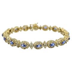 Oval Cut Tanzanite and Diamond Halo Line Bracelet in 14 Karat Yellow Gold