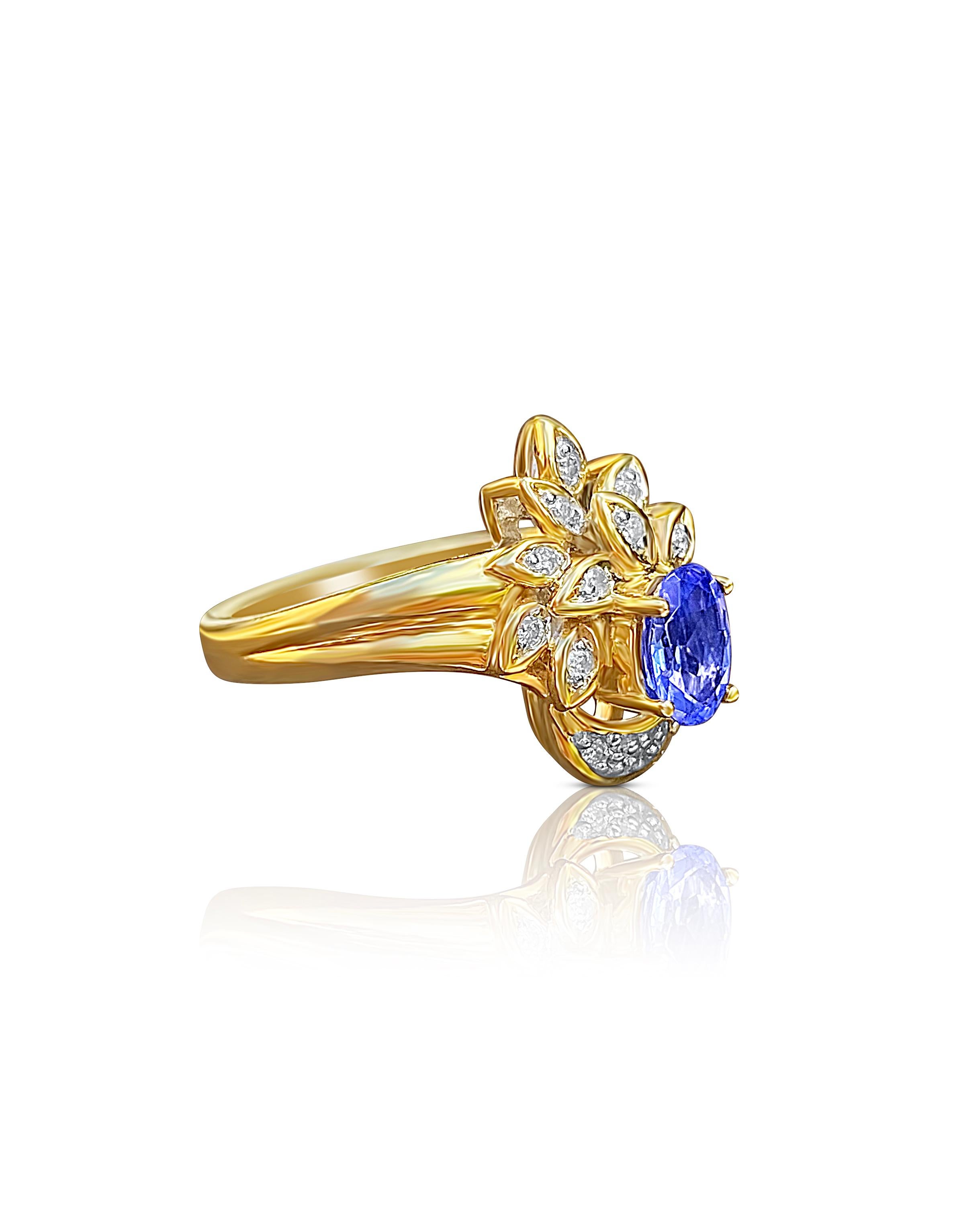 Centering a 0.69 Carat Oval-Cut Cornflower Blue Tanzanite, accented in a crown floral style by 0.11 carats of Round-Brilliant Cut Diamonds, and set in 14K Yellow Gold. 

Details:
✔ Stone: Tanzanite
✔ Center-Stone Weight: 0.69 carats
✔ Stone Cut: