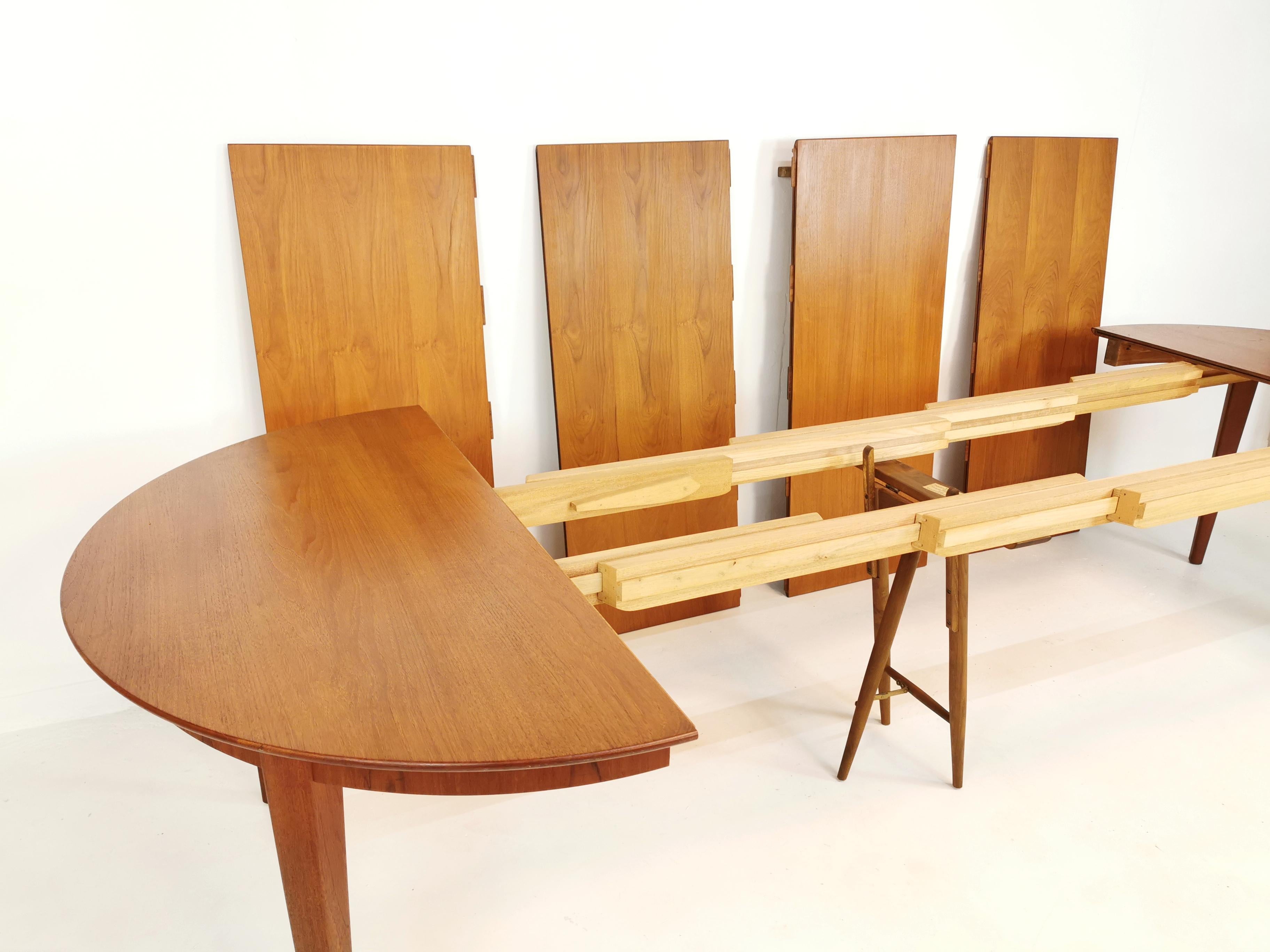 Oval danish dining table by Henning Kjaernulf. 

Designed by Henning Kjærnulf and manufactured in Denmark by Sorø Stolefabrik. 1960s.

It is made from solid teak with a matched veneer. 

4 separate leaves extend the table to seat 10-12 people