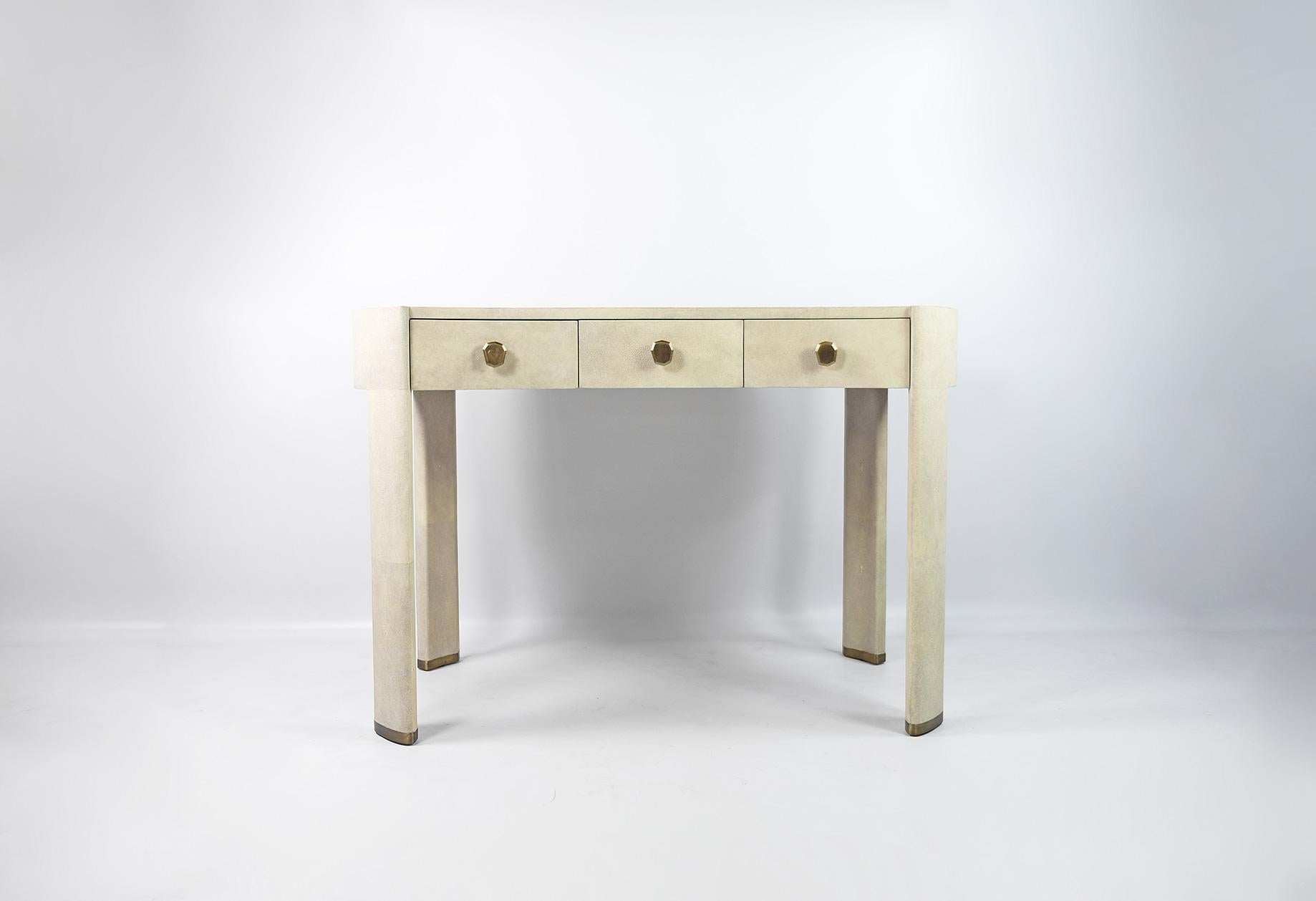 This desk is made of original shagreen in a natural colour, with brass caps on the legs.
It has three drawers with brass handles.

It can be used as a writing desk or as a vanity table in a bedroom.

The dimensions of the table are W45.2
