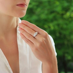 Anello a tre pietre con cluster floreale di diamanti ovali incastonato in platino