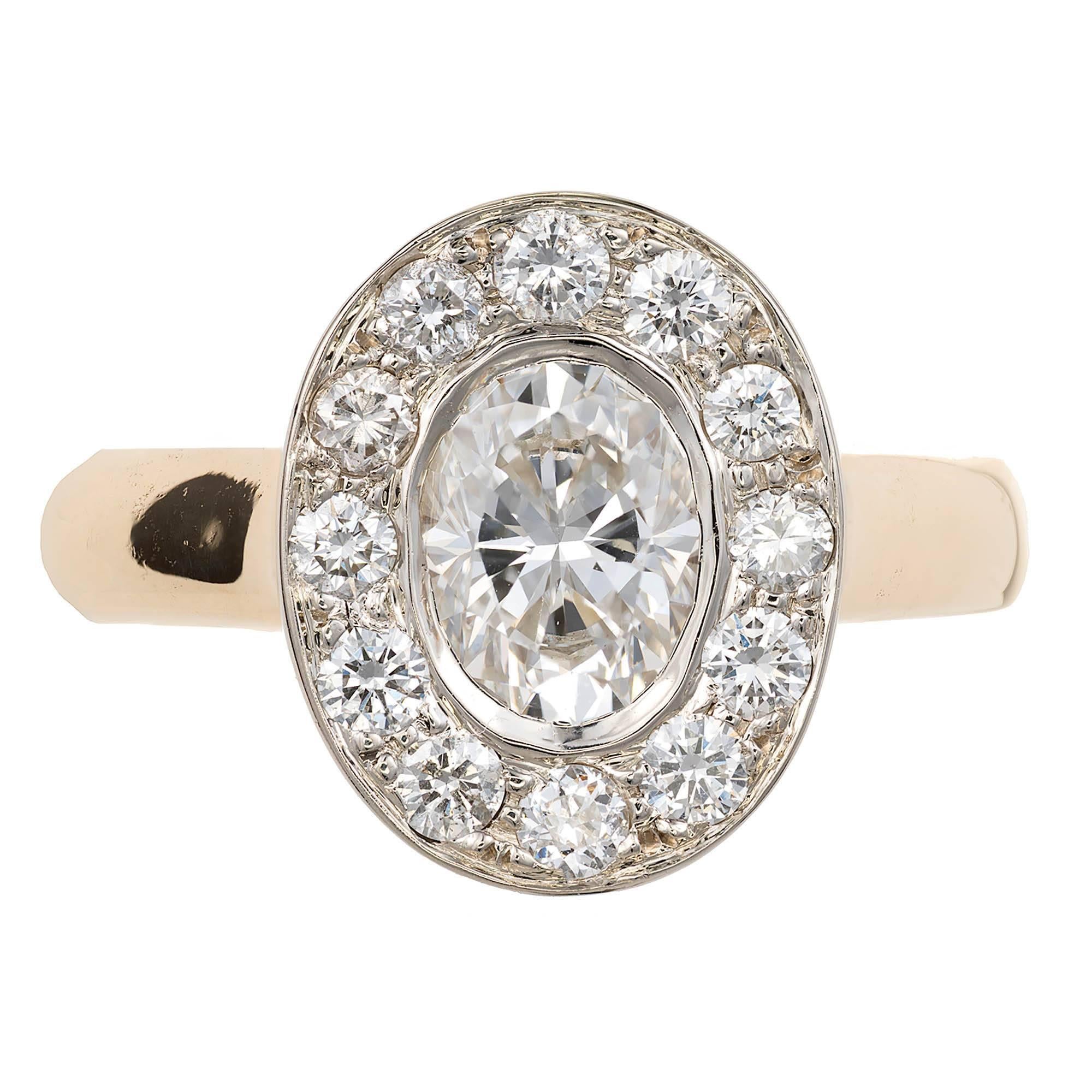 Oval diamond halo engagement ring in a solid 14k yellow gold setting, with a white gold top set with bright white shiny full cut diamonds surrounding an Ideal cut oval diamond 1.02ct. A wedding band fits flush against the side.

1.02ct oval diamond